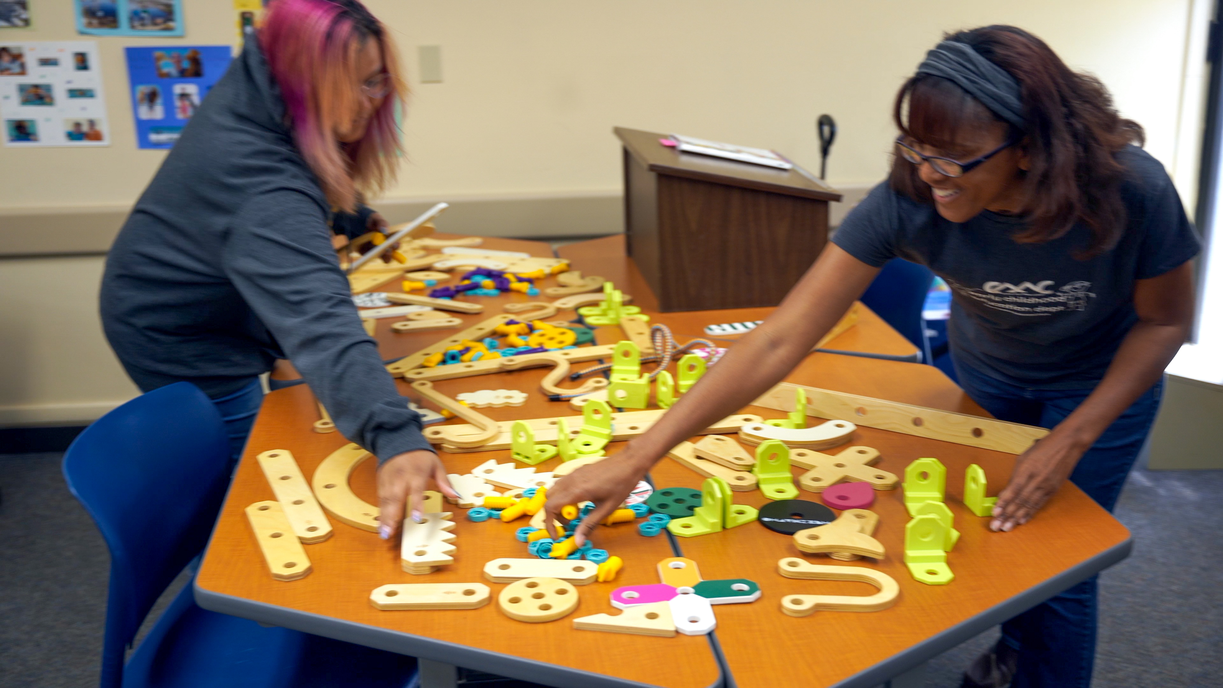 two people playing with creative building toys on a table