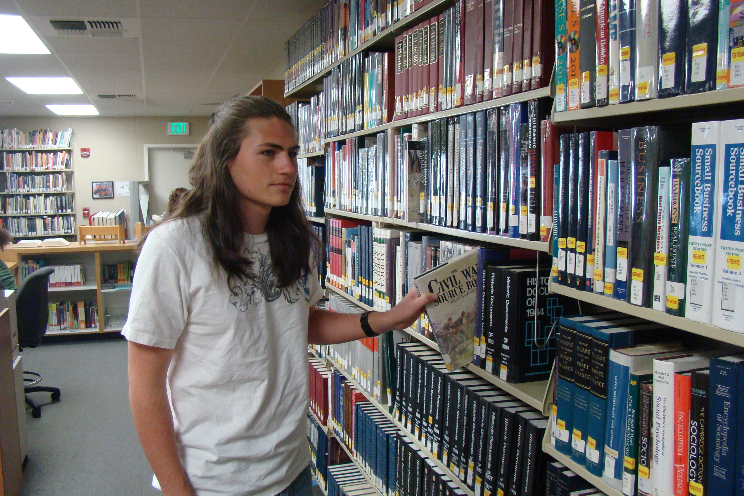student putting a book back at the library