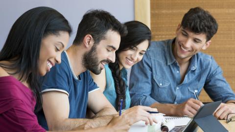 group of students smiling and studying together