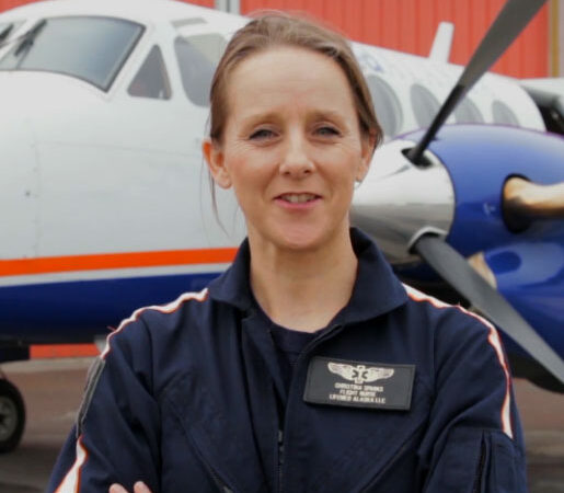 female instructor standing in front of a plane