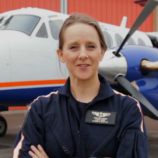 female instructor standing in front of a plane