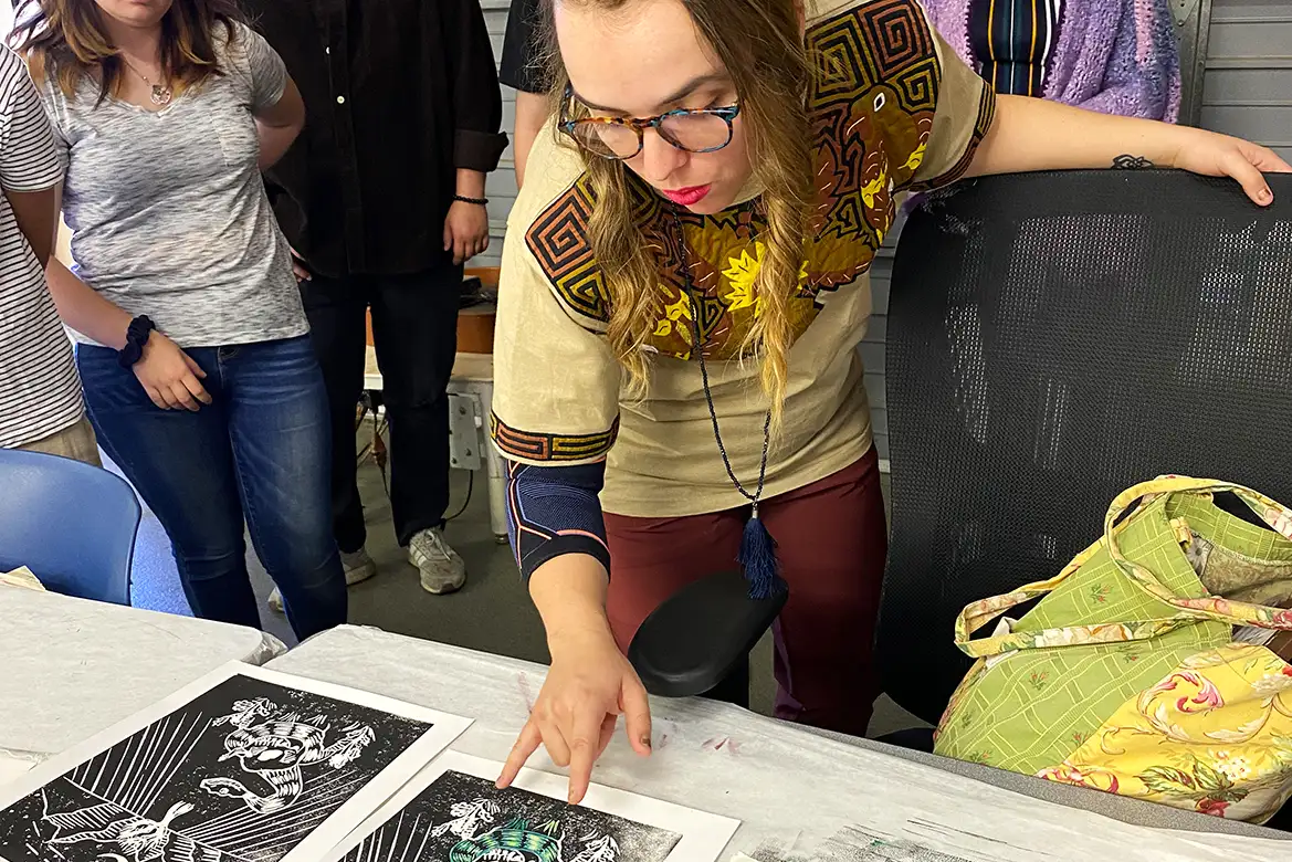 art student looking at drawing of skull with a snake wrapped around it