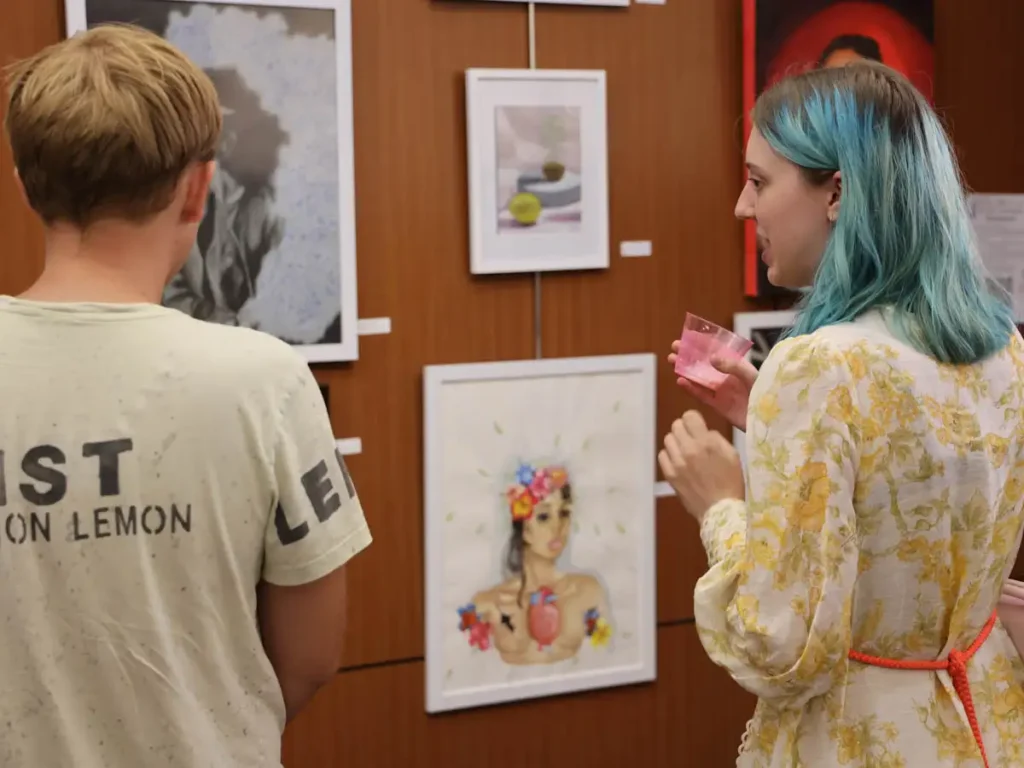 people having a drink and observing artwork