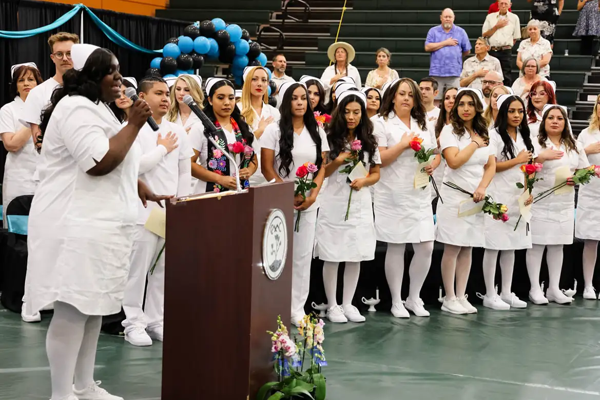 nursing student graduate singing the national anthem at the