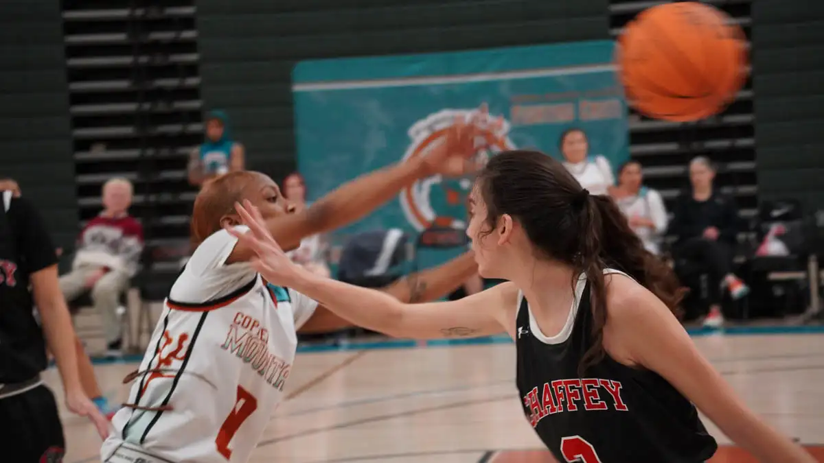 teammate passing the ball over her defender