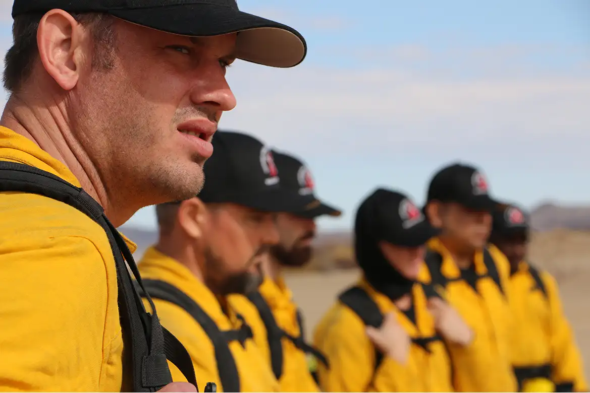 group of men in yellow coats and backpacks