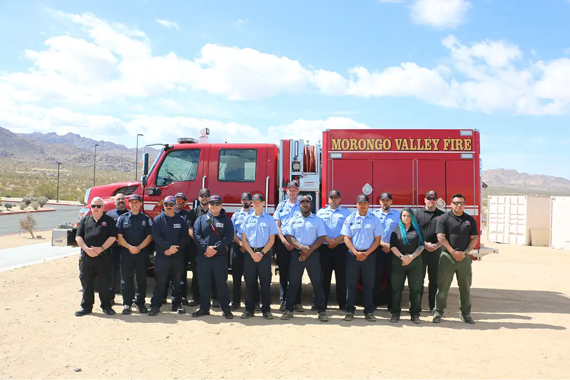 side view of the Morongo Valley fire truck with group of firefighters