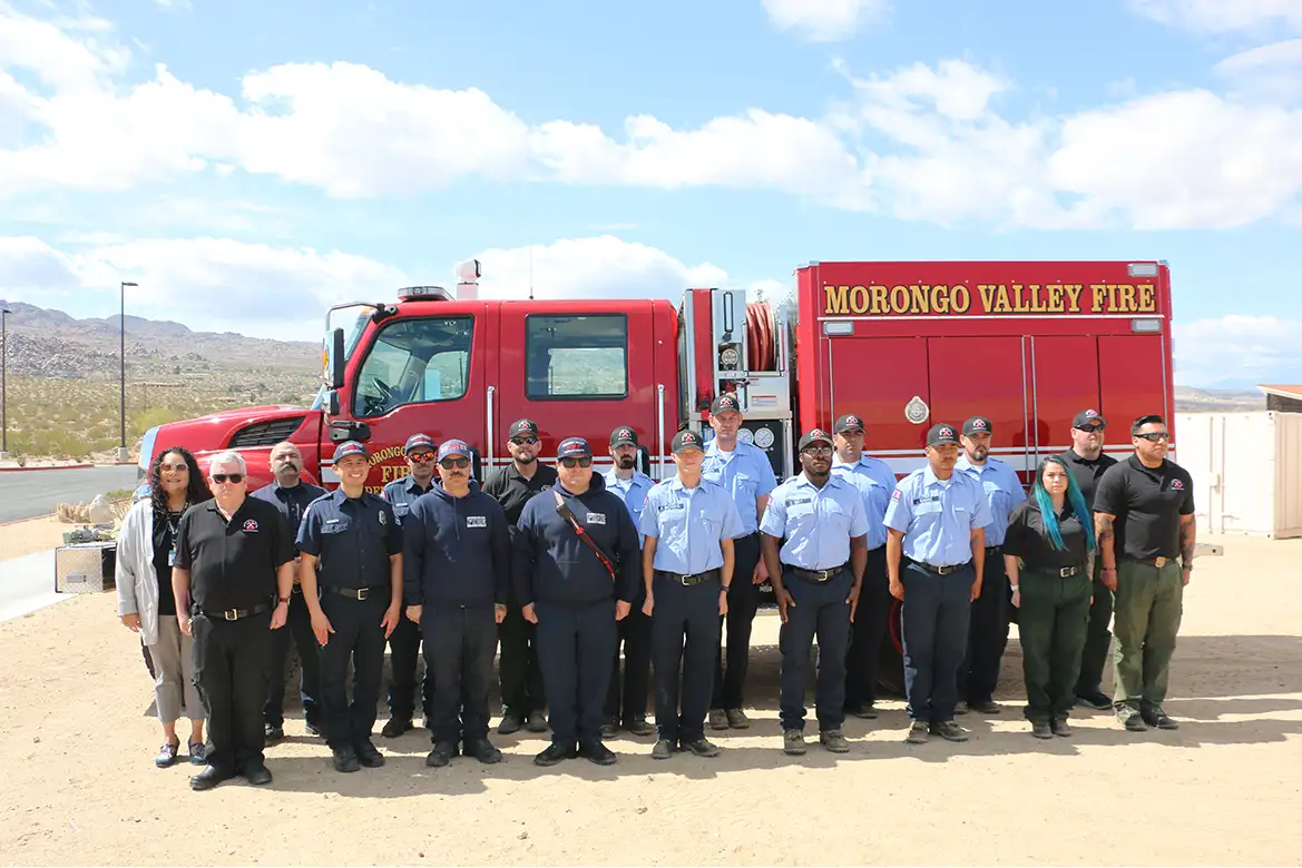 side view of the Morongo Valley fire truck with group of firefighters