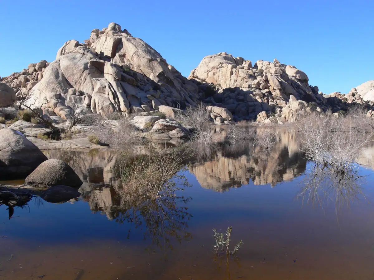 rocky hills sitting beside a small pond of water