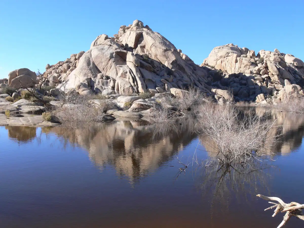 rocky hills sitting beside a small pond of water
