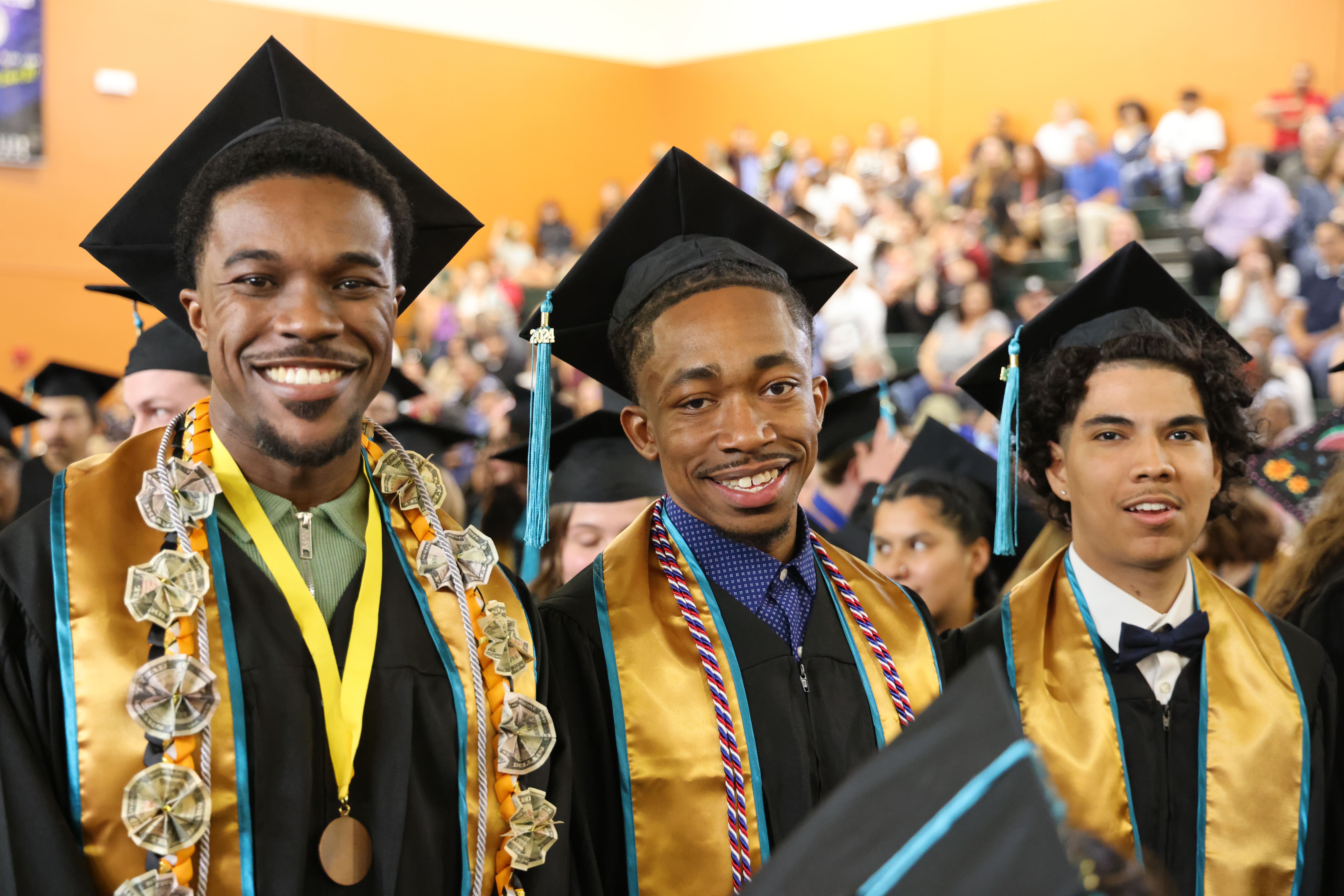CMC celebrates the Class of 2025 - an image of three smiling graduates at Commencement.