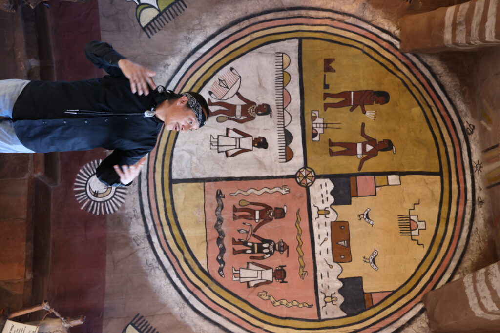 Hopi/Tewa singer/songwriter, artist, and activist, Ed Kabotie, discusses the artwork of his grandfather inside the Desert View Watchtower at the Grand Canyon.